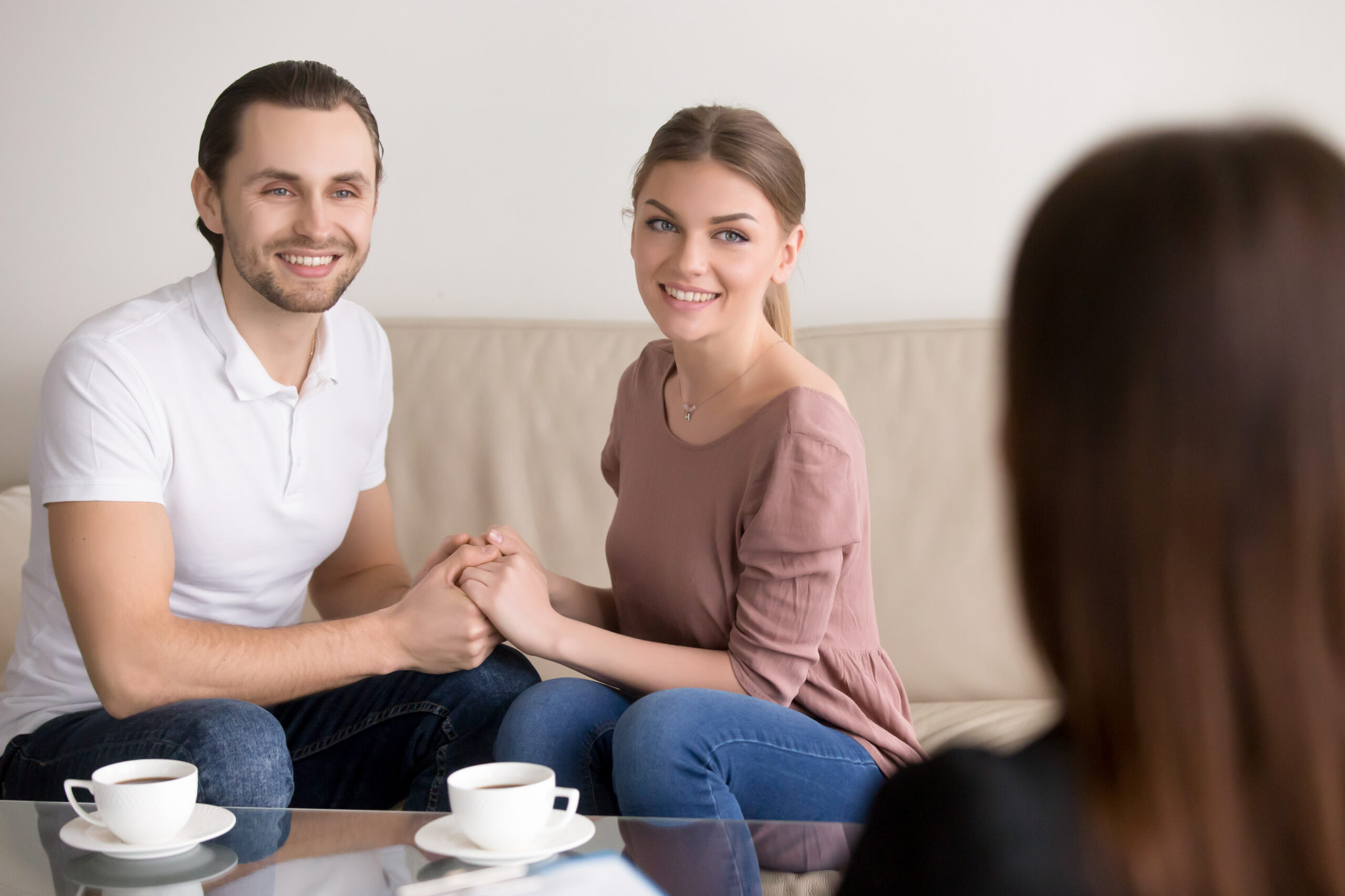 Couples therapy in Aurora — a smiling couple holding hands during a consultation at Aurora Village Therapy